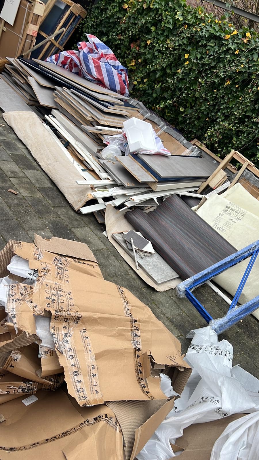 Gestapeld plaatmateriaal en laminaat klaargezet voor afvoer