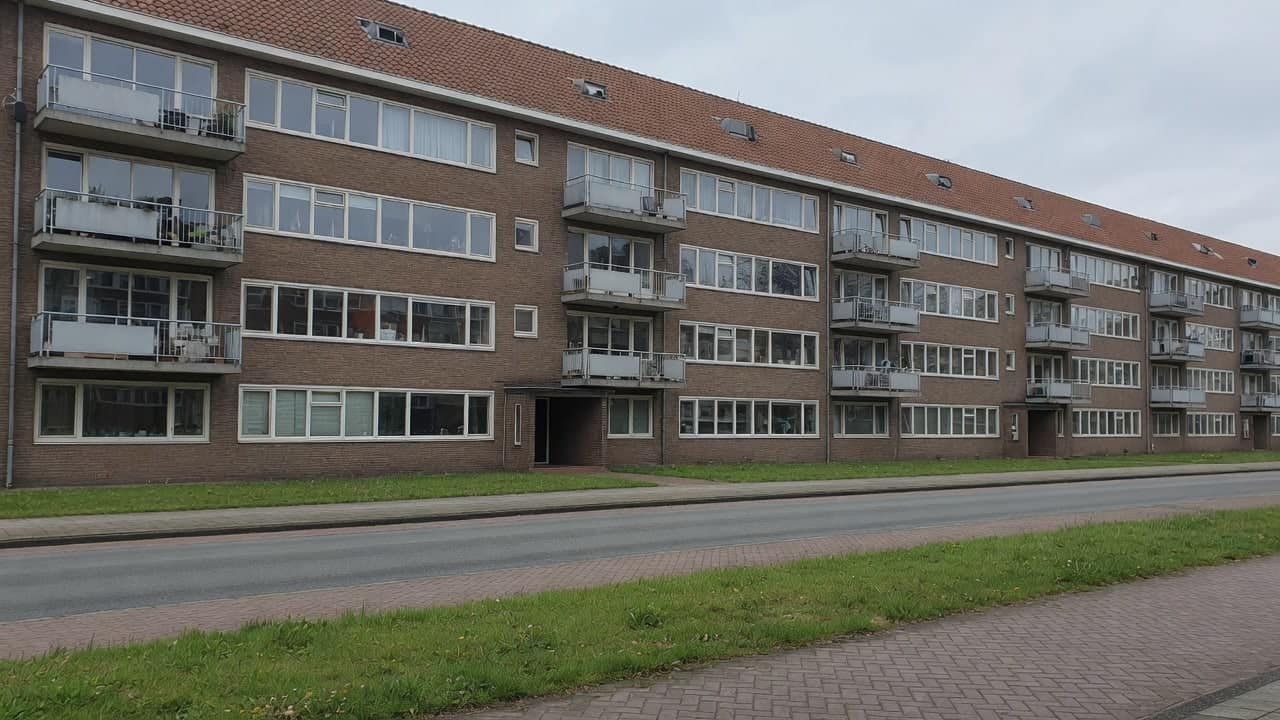 Naoorlogse portiekflat in bruine baksteen met doorlopende raamstroken